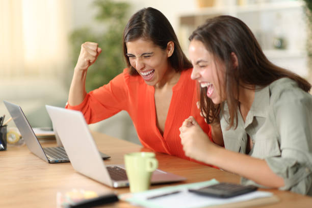istock Two excited tele workers celebrating success online 1921903341