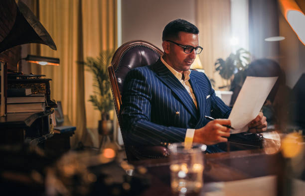 istock Businessman reading documents and uses the phone and computer in the office 1921914769