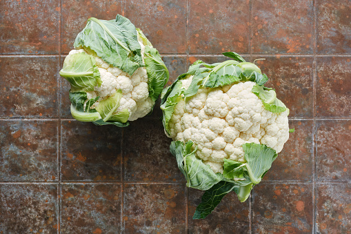 Fresh organic cauliflower on brown table in a kitchen. Top view.