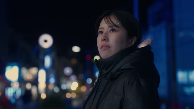 Portrait of Asian woman in city at night