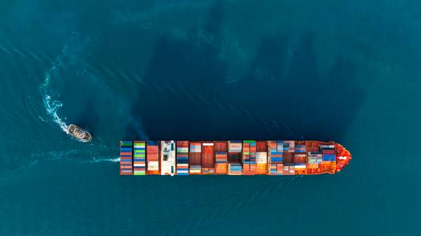istock Aerial side view of smart cargo ship carrying container from custom container depot. 1921976729
