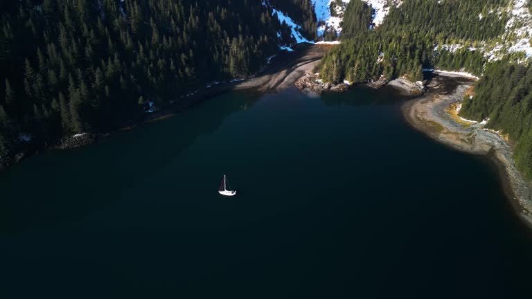 Drone shot around a sailboat moored in front of the Knight Island in sunny Alaska