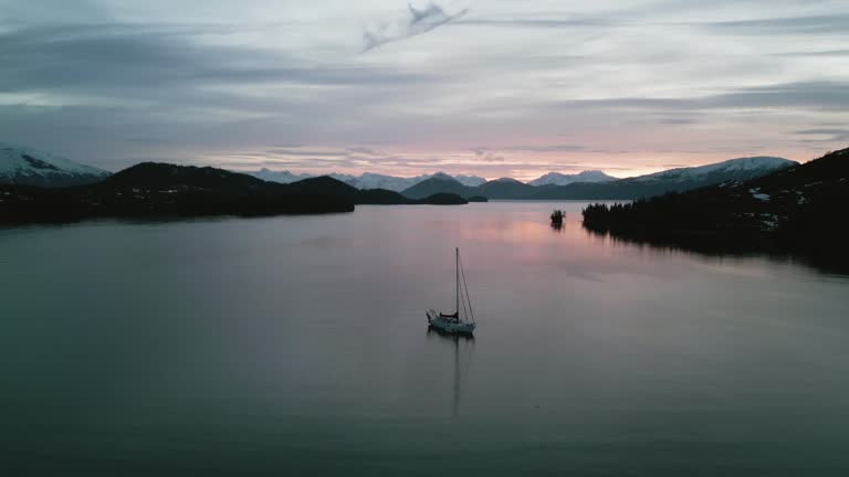 Panoramic drone shot circling a sailing boat anchored in middle island in Alaska