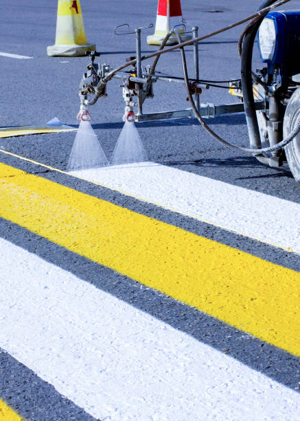 istock a team of workers drawing a pedestrian crossing in early spring using automated equipment on fresh asphalt 1921983614