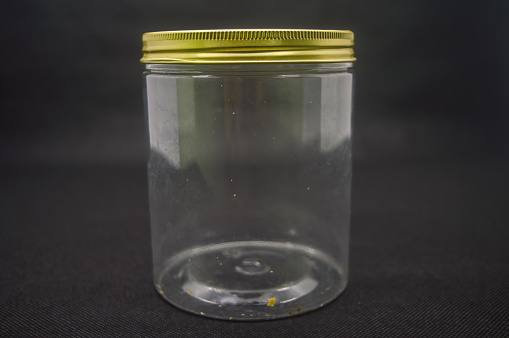 a minimalist plastic jar isolated on black background
