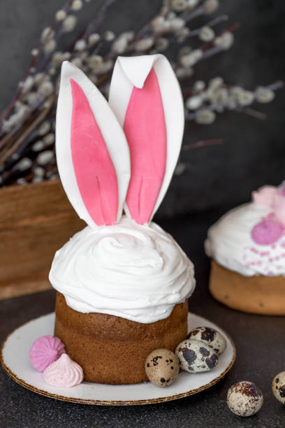 istock Beautiful stylish still life. Easter cake with rabbit ears, meringue, marshmallows, Easter eggs and willow twigs on a dark background. happy Easter. 1922009383