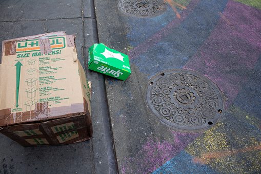 nyc, United States – January 07, 2024: A cardboard box on the side of the street in front of a sidewalk in New York, United States