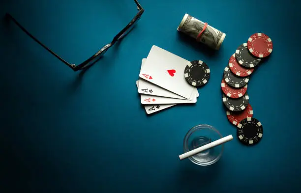 Photo of A popular poker game with a combination of four of a kind or quads. Chips and aces playing cards on a blue table in a poker club