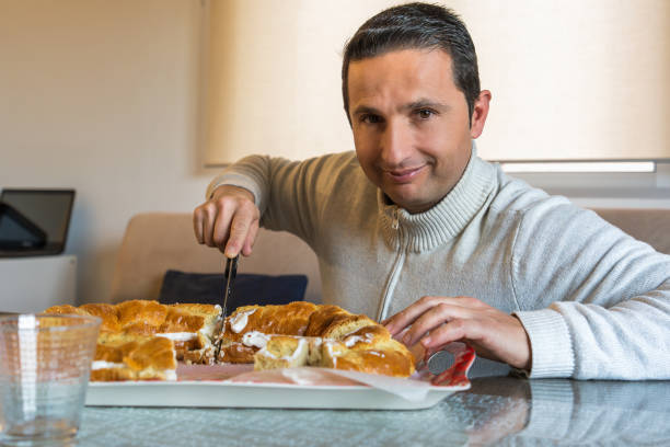 istock A young man smiles while he cuts a roscon de reyes 1922067222