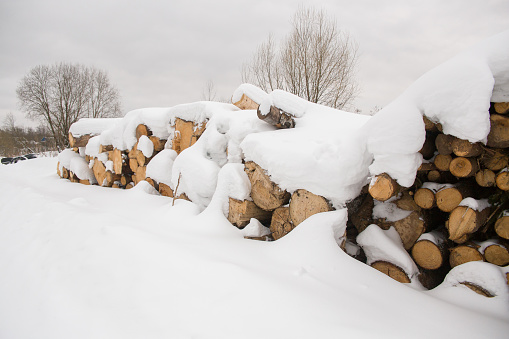 A stack of sawn wood covered with snow.