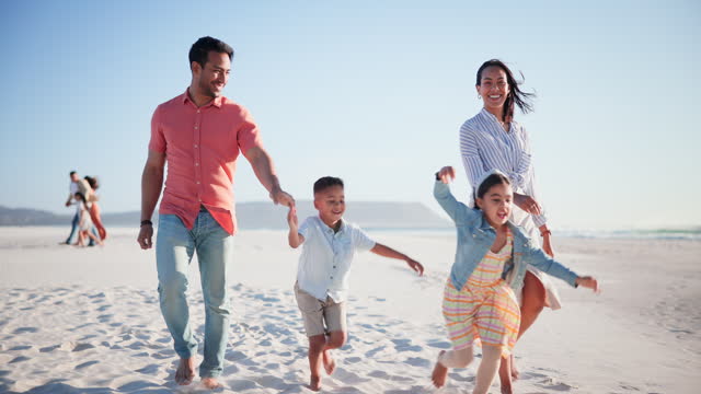 Parents, kids and holding hands for walk, beach or happy with running race on sand in summer. Father, mother and children for care, love and bonding with freedom, smile or play by ocean, waves or sea