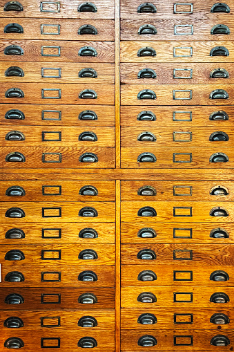 A wooden old vintage shelf of filing cabinets in a library. Sorting, organizing, knowledge