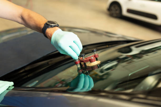 istock Mechanic using repairing equipment to fix damaged windshield, windshield repairing, 1922108066