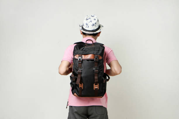 attractive asian man backpacker back pose portrait. travelling concept. on isolated background