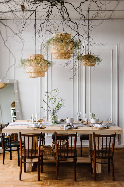 istock Happy easter dinner with decor at home. Minimalist composition in living room with copy space, hanging lamp, candle, easter eggs, vase with twig, branch, leaves. Interior design of easter dining room 1922154662