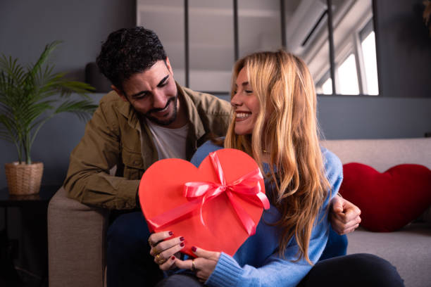 istock Loving young couple with heart-shaped gift box. Valentine's Day Celebration 1922198942