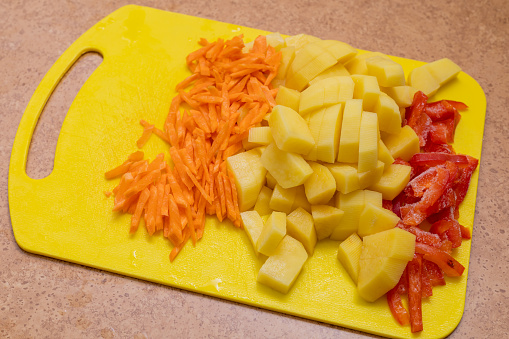 Cutting vegetables, carrot, potatoes and pepper. Healthy eating.