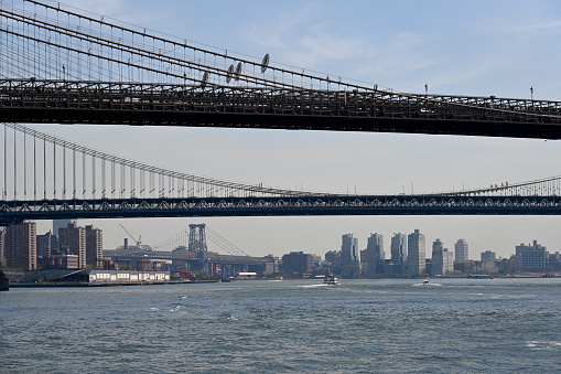 New York City, New York, USA, April 14, 2023 - The Williamsburg Bridge in the background, Brooklyn Bridge and Manhattan Bridge in the foreground as seen from South Street Seaport - Pier 17 in Lower Manhattan, New York City.