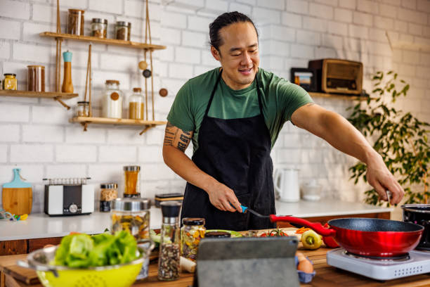 istock Handsome Chinese man frying vegetables 1922218177