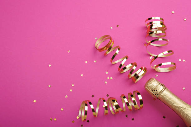 istock Champagne bottle with confetti stars on color background, space for text 1922218179