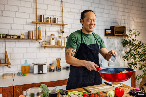 istock Smiling Chinese man cooking healthy meal 1922218705