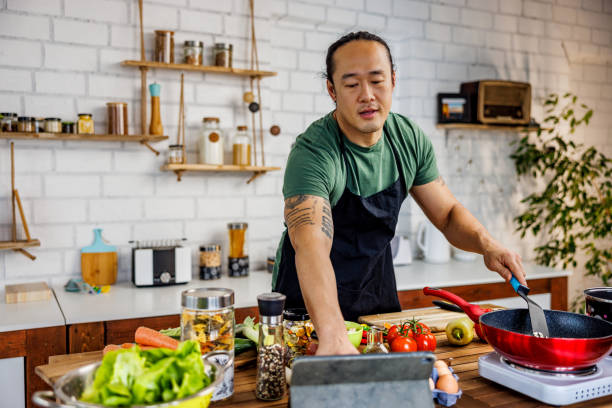 istock Chinese chef looking recipe online 1922218739
