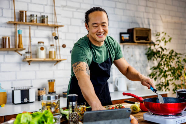 istock Smiling Chinese man looking recipe on digital tablet 1922219242