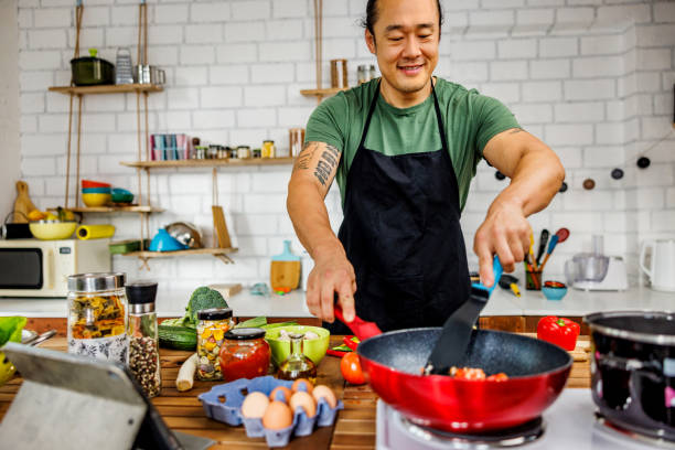 istock Chinese man frying vegetables in the kitchen 1922220282