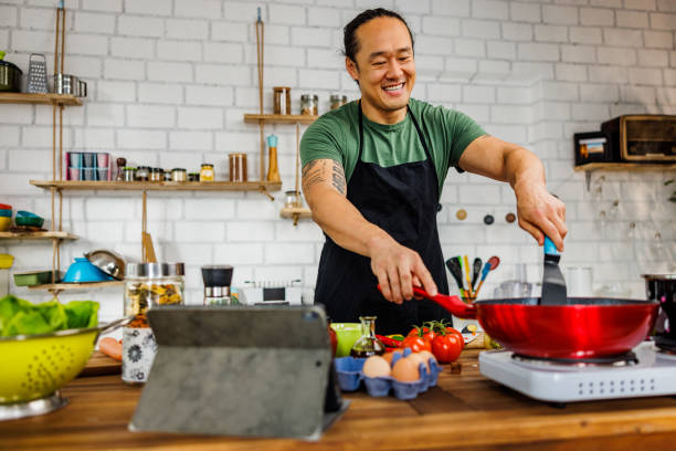 istock Smiling man enjoys cooking 1922220283