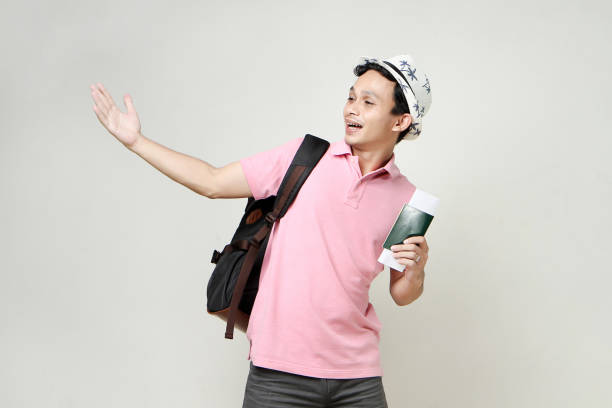 Asian man backpacker holding passport. digital nomad and travelling concept. on isolated background