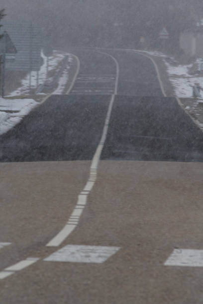 istock Snowy and foggy empty road, vertical photo 1922255577