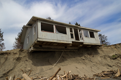 House falling into the ocean from a landslide