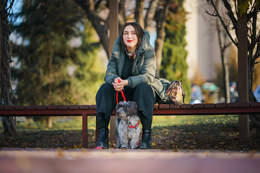 Young woman and her dog in public park