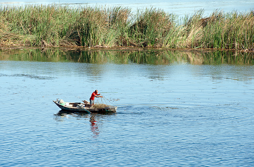 Lone traditional fisherman, River Nile, Egypt.The River Nile has always and continues to be a lifeline for Egypt. Trade, communication, agriculture, water and now tourism provide the essential ingredients of life - from the Upper Nile and its cataracts, along its fertile banks to the Lower Nile and Delta. In many ways life has not changed for centuries, with transport often relying on the camel on land and felucca on the river