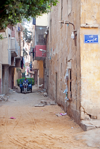 Giza backstreet scene, Cairo, River Nile, Egypt. The River Nile has always and continues to be a lifeline for Egypt. Trade, communication, agriculture, water and now tourism provide the essential ingredients of life - from the Upper Nile and its cataracts, along its fertile banks to the Lower Nile and Delta. In many ways life has not changed for centuries, with transport often relying on the camel on land and felucca on the river