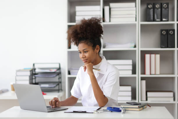 istock Serious african female doctor working stressed with paperwork in office. 1922323155
