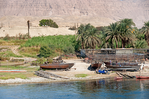 Boatbuilding construction scene, banks of the River Nile, Egypt. The River Nile has always and continues to be a lifeline for Egypt. Trade, communication, agriculture, water and now tourism provide the essential ingredients of life - from the Upper Nile and its cataracts, along its fertile banks to the Lower Nile and Delta. In many ways life has not changed for centuries, with transport often relying on the camel on land and felucca on the river