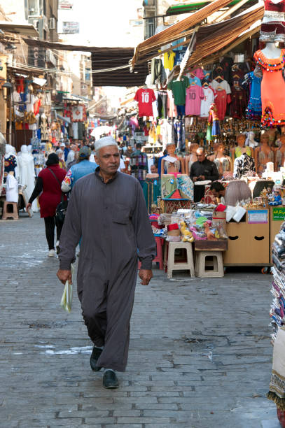 un hombre musulmán camina por la escena callejera del mercado de khan khalili, el cairo, río nilo, egipto. - el khalili fotografías e imágenes de stock