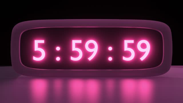 Digital alarm clock with pink clockface waking up at 6 AM. The numbers on the clock screen changes from 5:55 to 6:00 AM. Close up view. Digital Red Alarm Clock Timekeeper