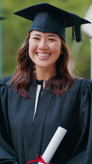 Woman, face and graduation at university, diploma or smile for pride, achievement or goal in education. Student, graduate or person in portrait, cap and gown at college, campus and excited in Japan