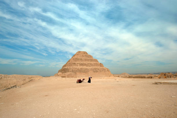 chameau et chauffeur devant la pyramide à degrés de djéser, saqqarah, nil, égypte - saqqara egypt pyramid shape pyramid photos et images de collection