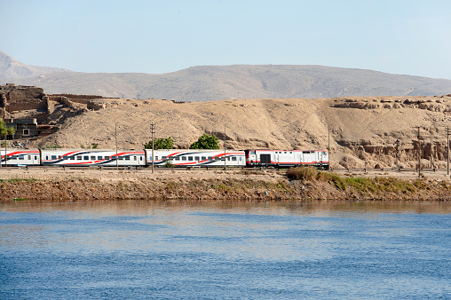 Express train in motion, banks of the Nile River, Egypt. The River Nile has always and continues to be a lifeline for Egypt. Trade, communication, agriculture, water and now tourism provide the essential ingredients of life - from the Upper Nile and its cataracts, along its fertile banks to the Lower Nile and Delta. In many ways life has not changed for centuries, with transport often relying on the camel on land and felucca on the river