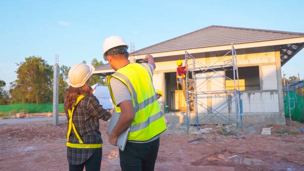 istock Asian male construction engineer talking to Asian female architects. standing at a construction site to explain install solar cells on the roof of the house. 1922368400