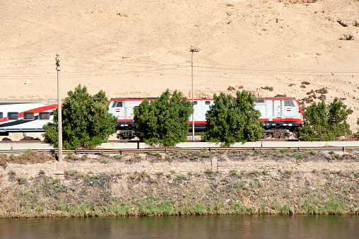 Express train in motion, banks of the Nile River, Egypt. The River Nile has always and continues to be a lifeline for Egypt. Trade, communication, agriculture, water and now tourism provide the essential ingredients of life - from the Upper Nile and its cataracts, along its fertile banks to the Lower Nile and Delta. In many ways life has not changed for centuries, with transport often relying on the camel on land and felucca on the river