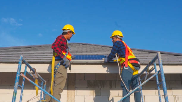 istock Two technicians installing solar panels on the roof of a house. 1922372827