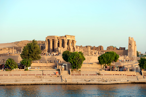 Double temple of Kom Ombo, Aswan governate, River Nile, Egypt. The Temple of Kom Ombo is a double temple in Kom Ombo,Aswan Governorate, Upper Egypt, constructed during the Ptolemaic dynasty dedicated to Sobek and Horus. The River Nile has always and continues to be a lifeline for Egypt. Trade, communication, agriculture, water and now tourism provide the essential ingredients of life - from the Upper Nile and its cataracts, along its fertile banks to the Lower Nile and Delta. In many ways life has not changed for centuries, with transport often relying on the camel on land and felucca on the river