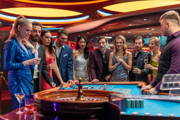 istock Multiethnic Young Adults Playing an Engaging Game of Roulette, Spending a Fun Evening in a Fancy Hotel Casino . Enthusiastic Gamblers Cheering Together, Congratulating a Happy Winner 1922375535