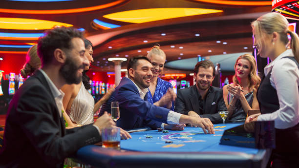 grupo de asistentes al casino que disfrutan del tiempo en un casino moderno, amigos que hacen apuestas de blackjack, crupier femenino profesional reparte cartas. personas de grupos diversos, jugando, haciendo apuestas, ganando y celebrando. - blackjack fotografías e imágenes de stock