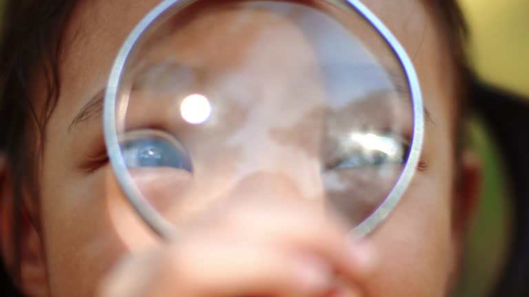 A girl looking through magnifying glass and smiling