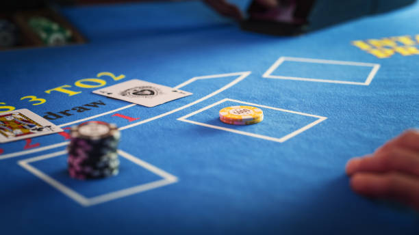 istock Close Up on Casino Baccarat Gambling Table: Anonymous Croupier Dealing Playing Cards on a Blackjack Table with Bet Chips in Place. Poker Chips are Being Exchanged as the Lucky Guest Wins the Jackpot 1922402674